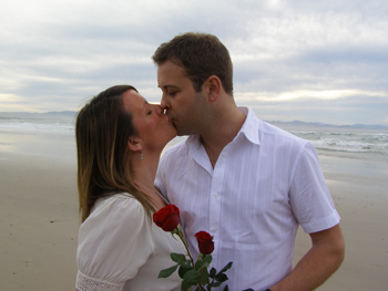 Andy Rebecca Kiss By Pacific Ocean and Exchange Red Roses for Renewal of Vows Ceremony with Marilyn Verschuure from Marry Me Marilyn at Wategos Beach Byron Bay NSW Australia